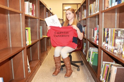 Erin Fallon showing off her acceptance with Caldwell University T-shirt and Kean University packet.