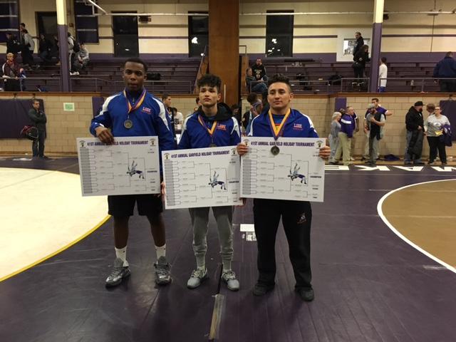 The three champions with their gold medals and brackets. 